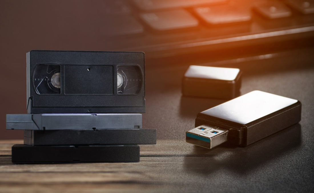 a USB next to a pile of VHS tapes 