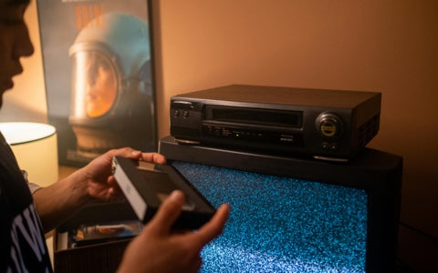 a person holding a VHS tape 