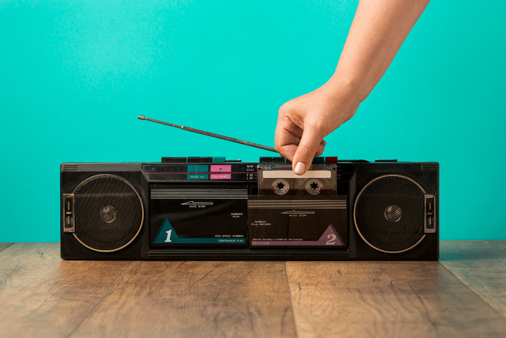 a person putting a tape in a vintage cassette player 