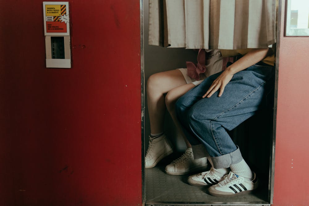 a couple sitting in a changing room wearing Shoe styles of the 80s