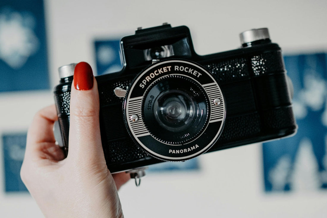 a person holding a camera choosing between using analog and digital cameras, 