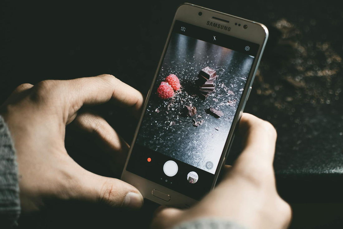 a man taking a photo of chocolate and raspberries