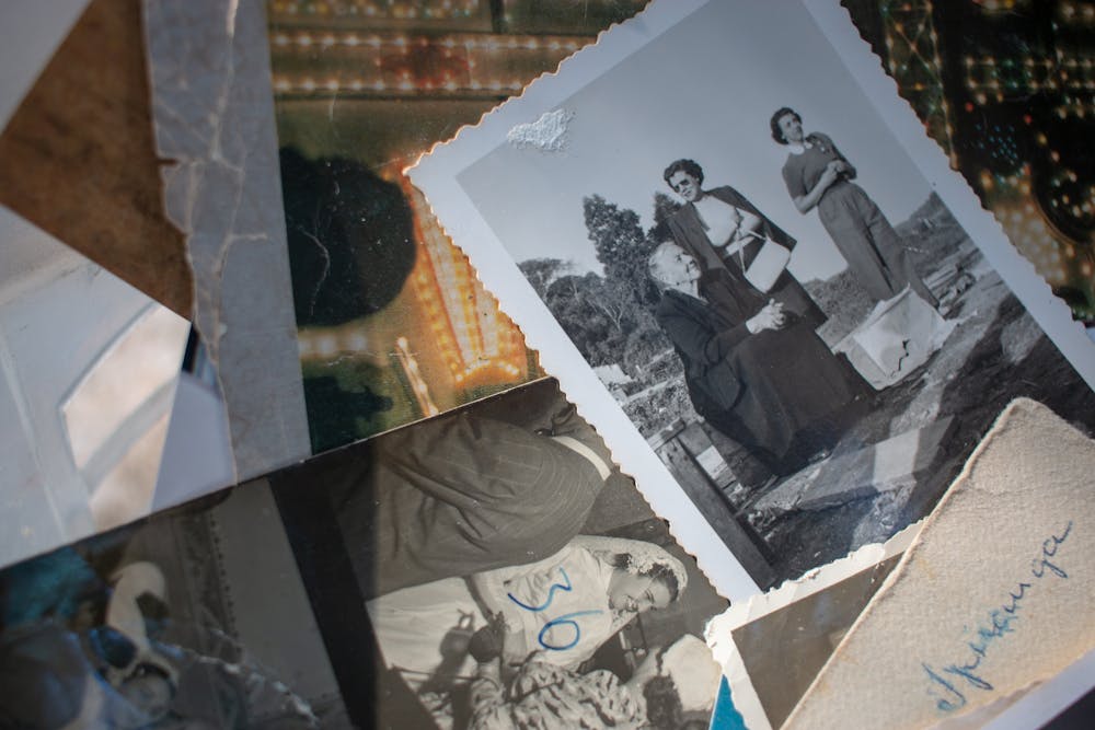 Close-up of scattered vintage family photos, including black-and-white portraits and handwritten notes.