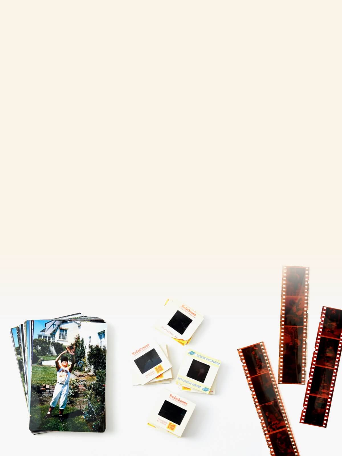 Old photographs and film negatives, with Kodak slide film boxes placed above the pictures and negatives.
