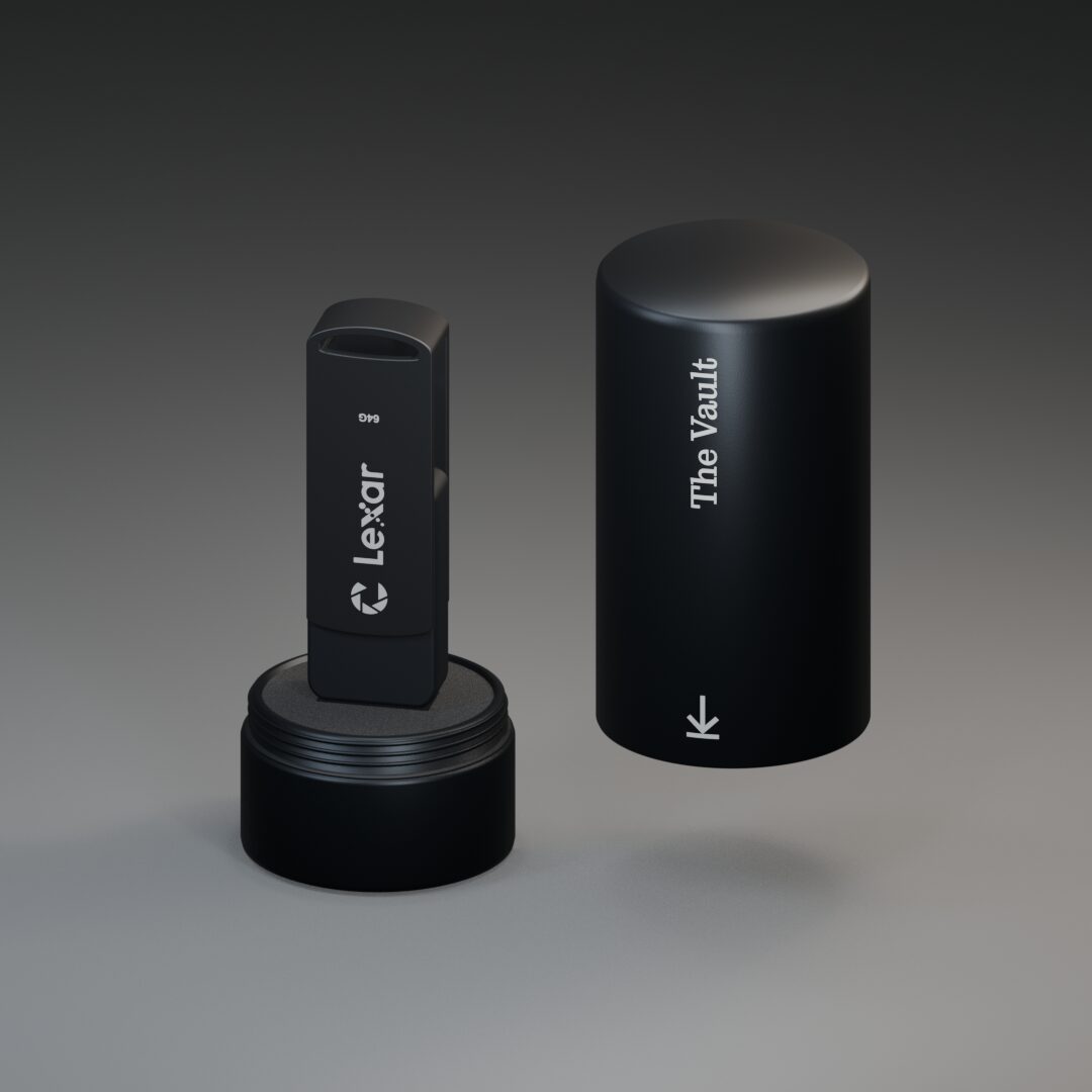 The Vault in Black: a black aluminum case with its screw-off cover beside it and a USB drive standing in the foam cradle